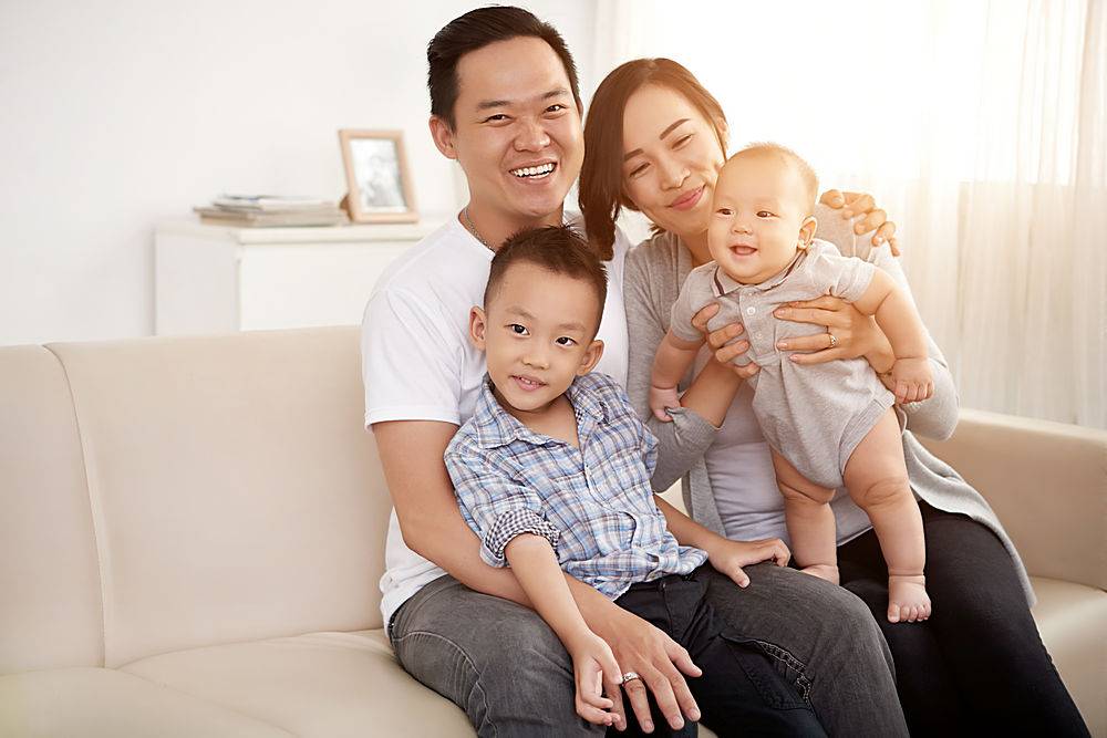 相爱的亚洲夫妇带着年幼的儿子和婴儿在家里_557732801