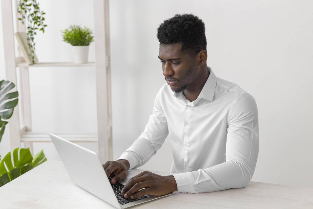 一名非洲裔美国男子在笔记本电脑上工作_11235005