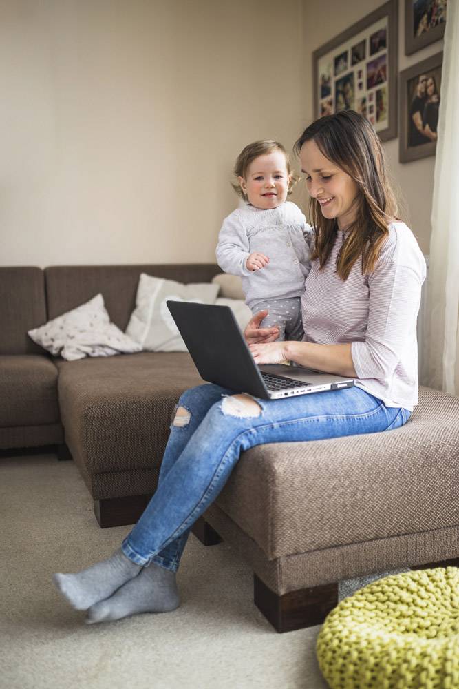 微笑的女人和她的女儿在笔记本电脑上工作_2593115
