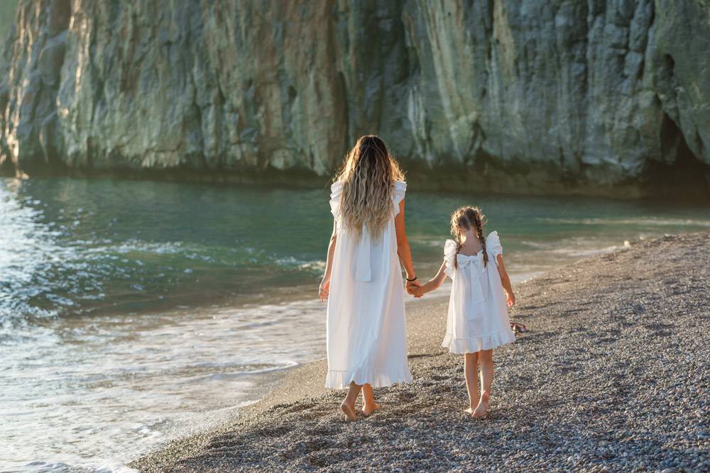 日落时分幸福的母女俩穿着白裙在海边散步_9178928