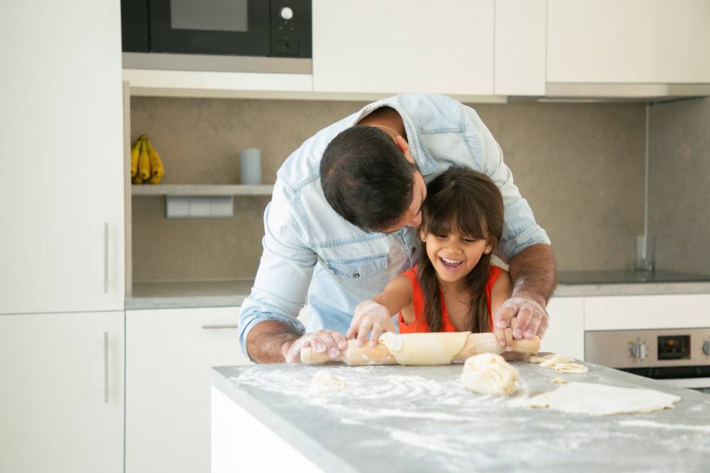 快乐的女孩和她的爸爸在厨房里一边滚一边揉_9988555