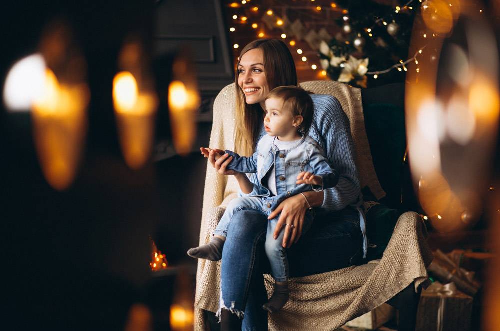 母亲带着女儿坐在圣诞树旁的椅子上_3655257
