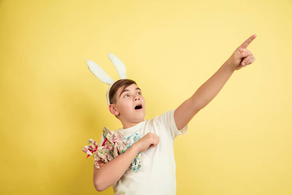 有明亮的情感的复活节兔子男孩在黄色演播室