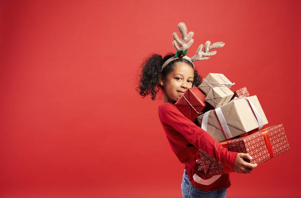 非洲女孩肖像携带圣诞礼物堆免费照片